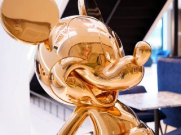 Close up of a life size golden Micky Mouse statue, in Disney Headquarters NYC